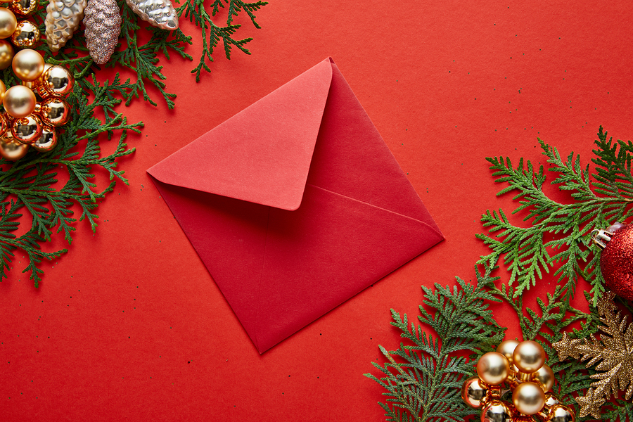Top View Of Red Envelope Near Shiny Christmas Decoration On Gree